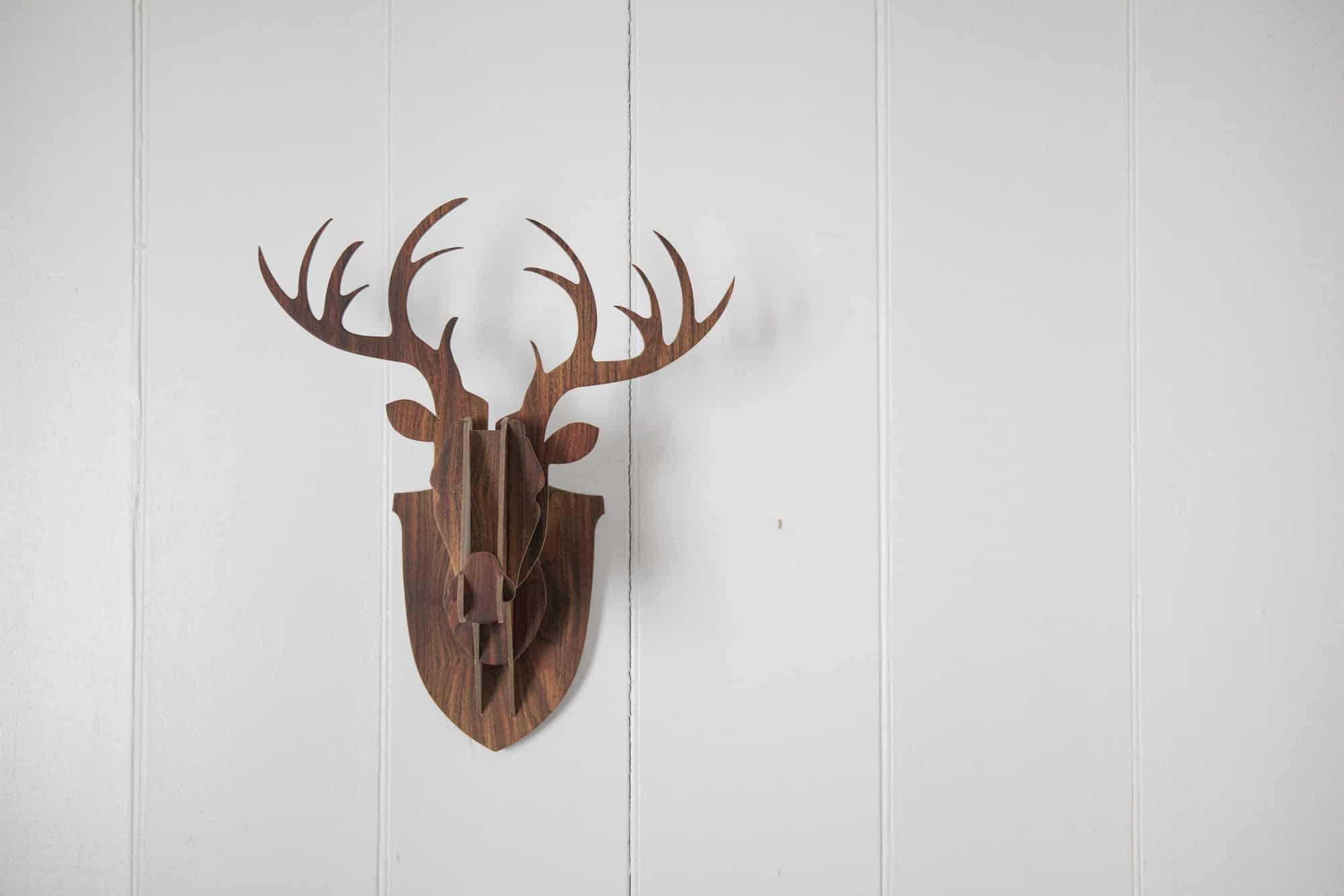 Statue of deer head made from puzzle on white blank wall